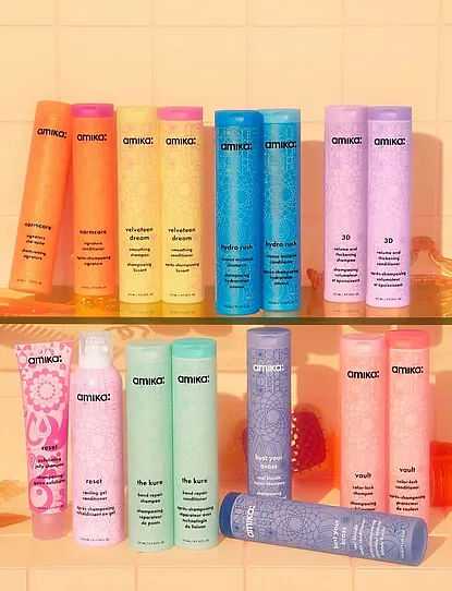 Row of colorful Amika hair care products against a coral background.
