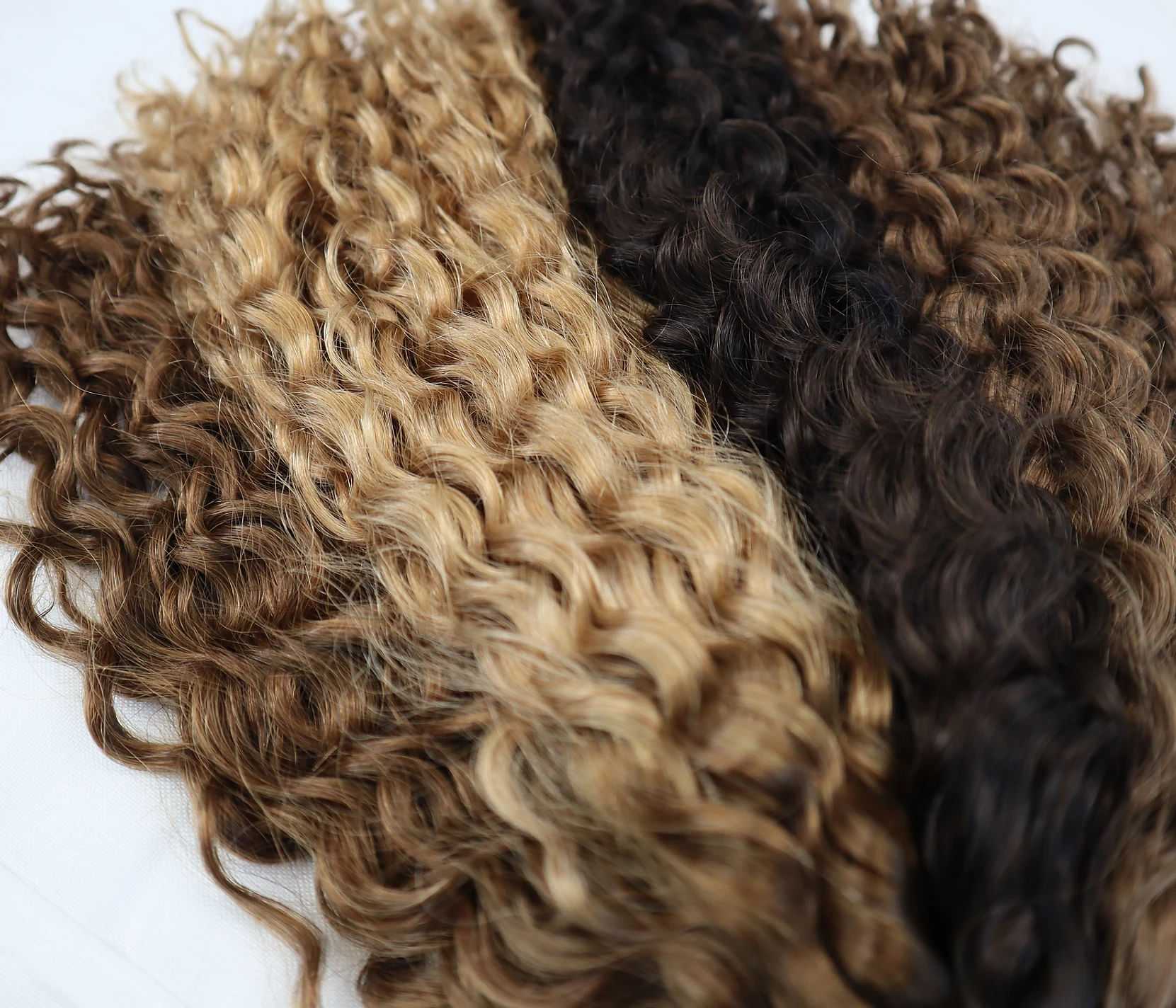 Different shades of curly hair extensions spread out.