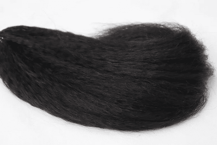 A tuft of black hair on a white background.